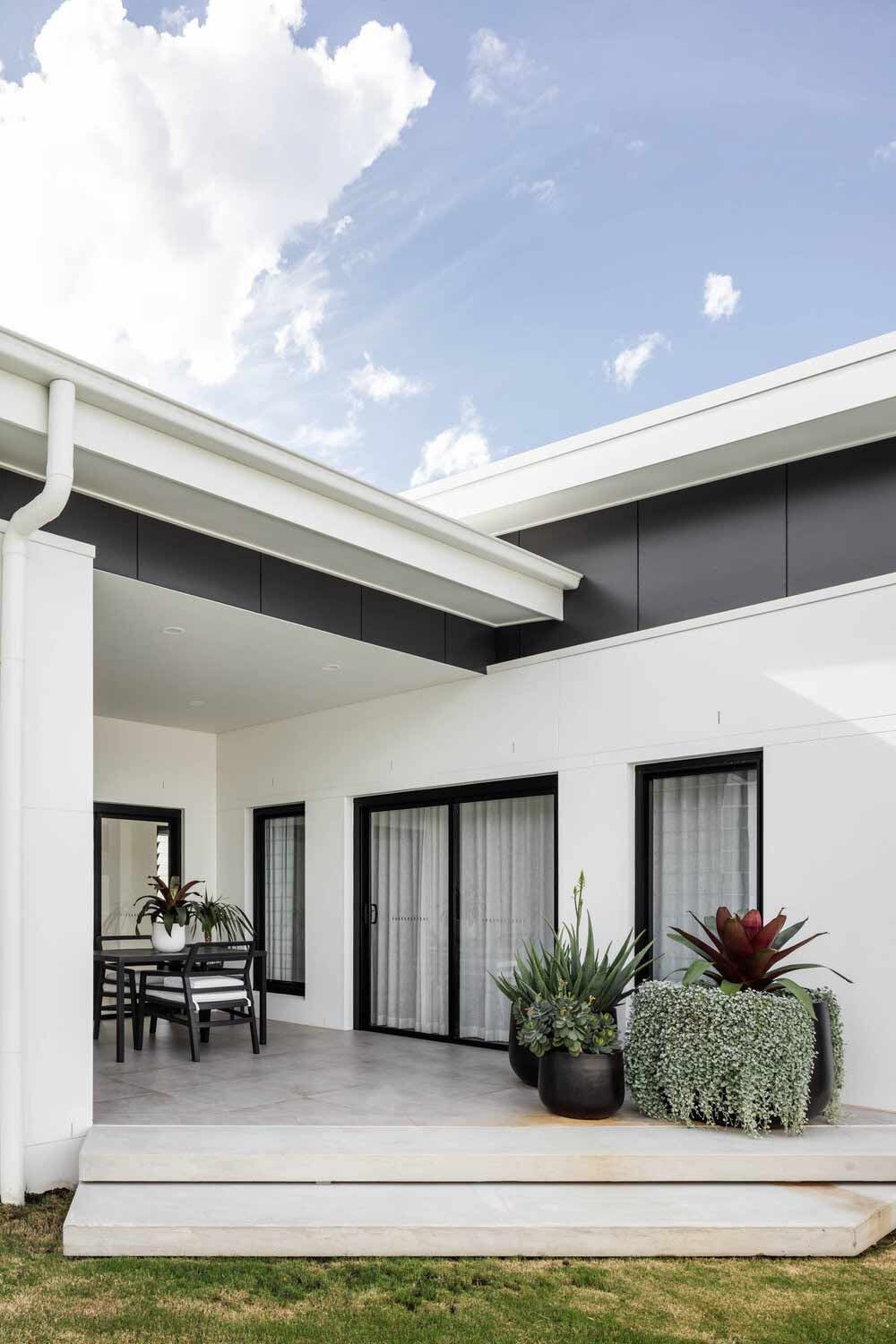 A White House With a Patio and a Table and Chairs on It — DeBu Studios In Russell Vale, NSW
