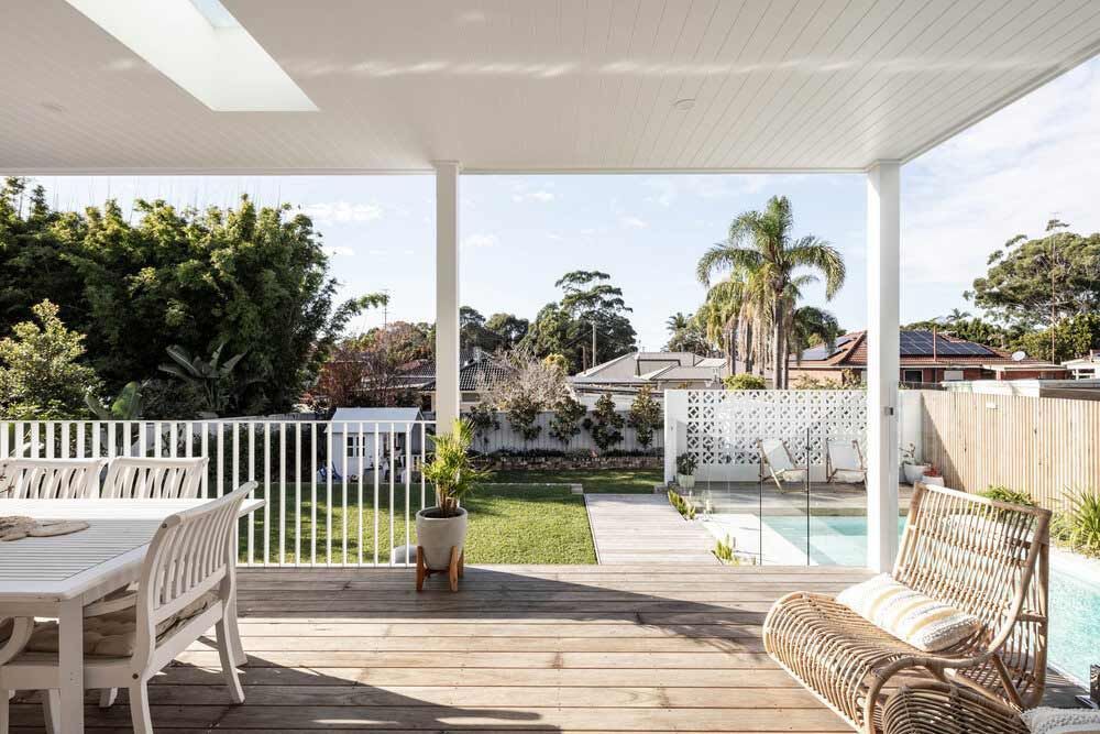 A Wooden Deck With a Table and Chairs Overlooking a Swimming Pool — DeBu Studios In Russell Vale, NSW