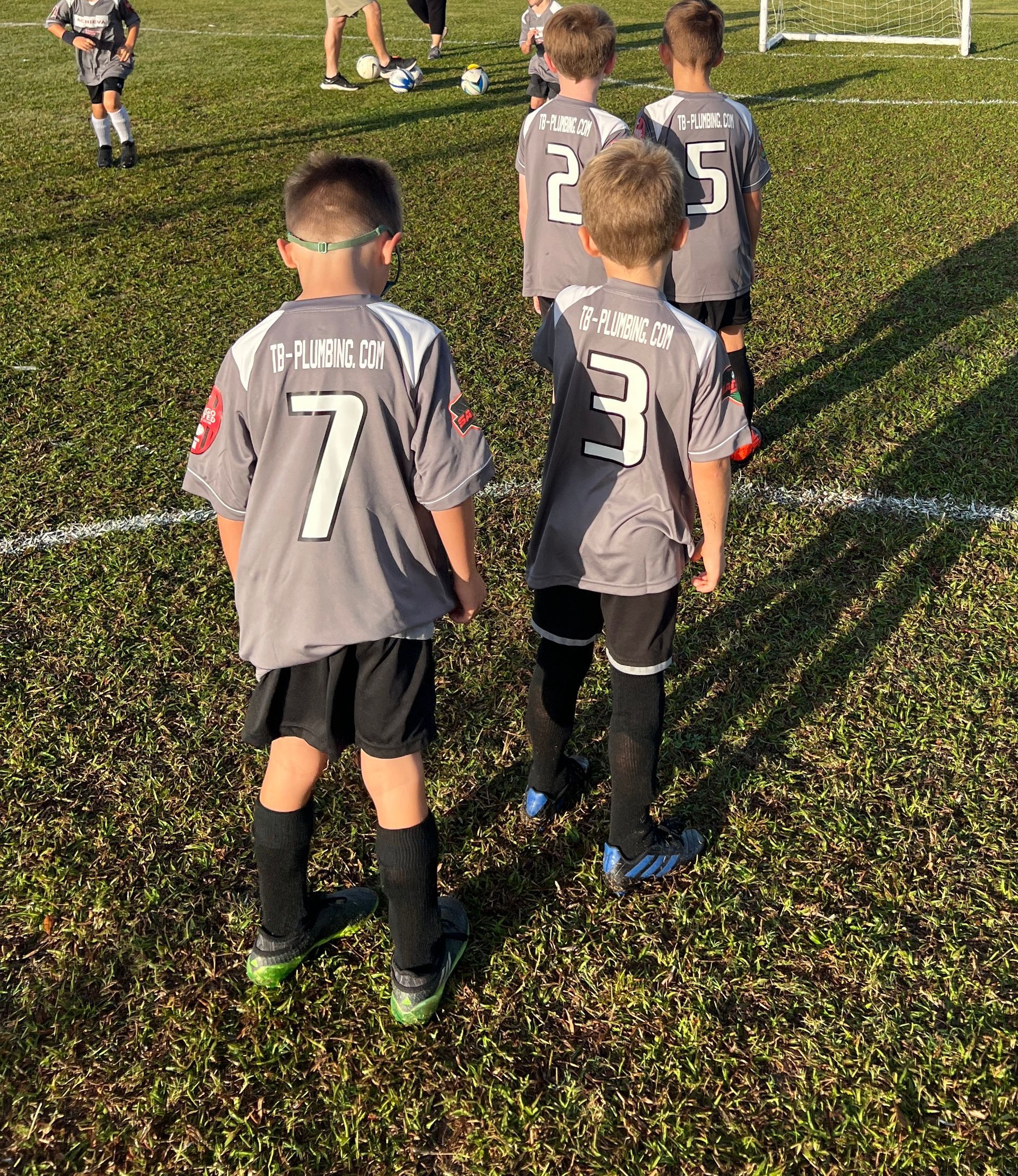 A group of young boys are playing soccer on a field.