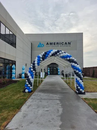 Exterior of the American Outdoor Brands building, a blue and black balloon archway over the entrance.