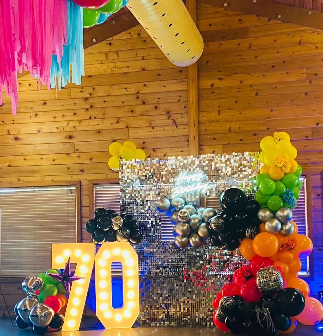 A room filled with balloons and a sign that says `` 70 ''.