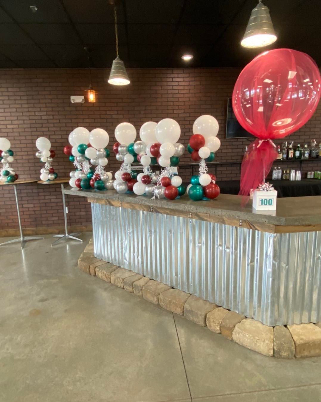 A bar decorated with balloons and a large red balloon.