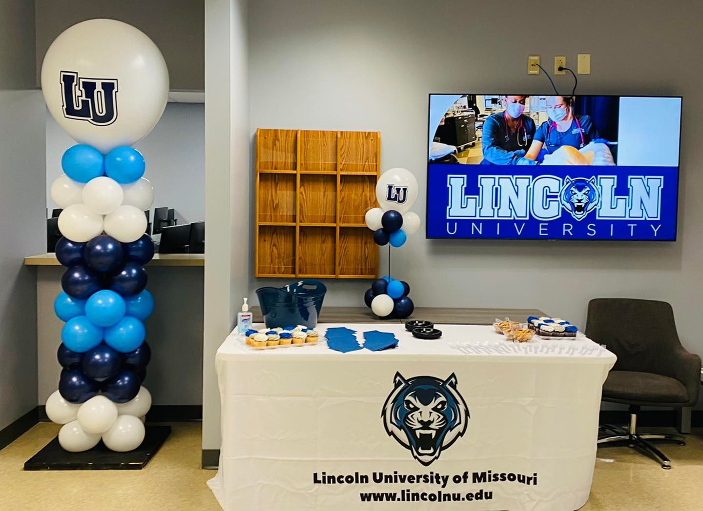 A table with balloons and a sign that says lincoln university
