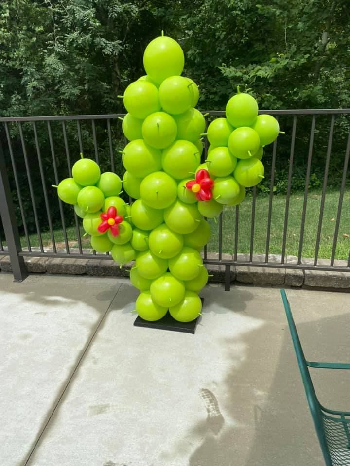 A cactus made out of green balloons on a patio
