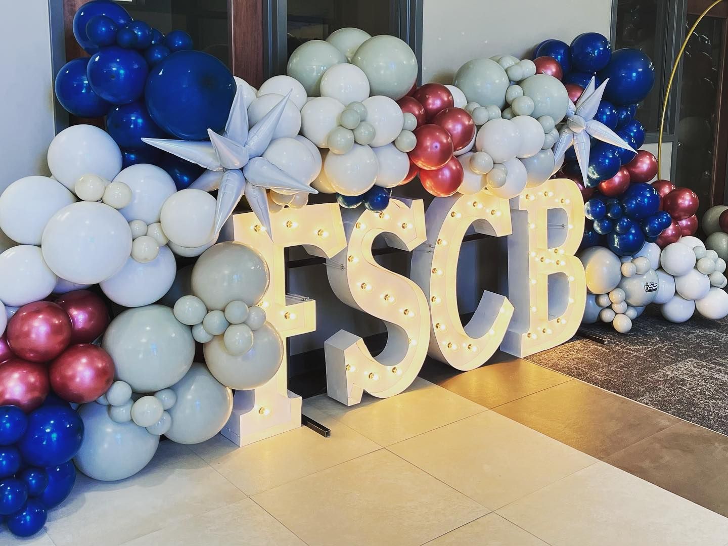 A large sign that says fscb is surrounded by balloons.