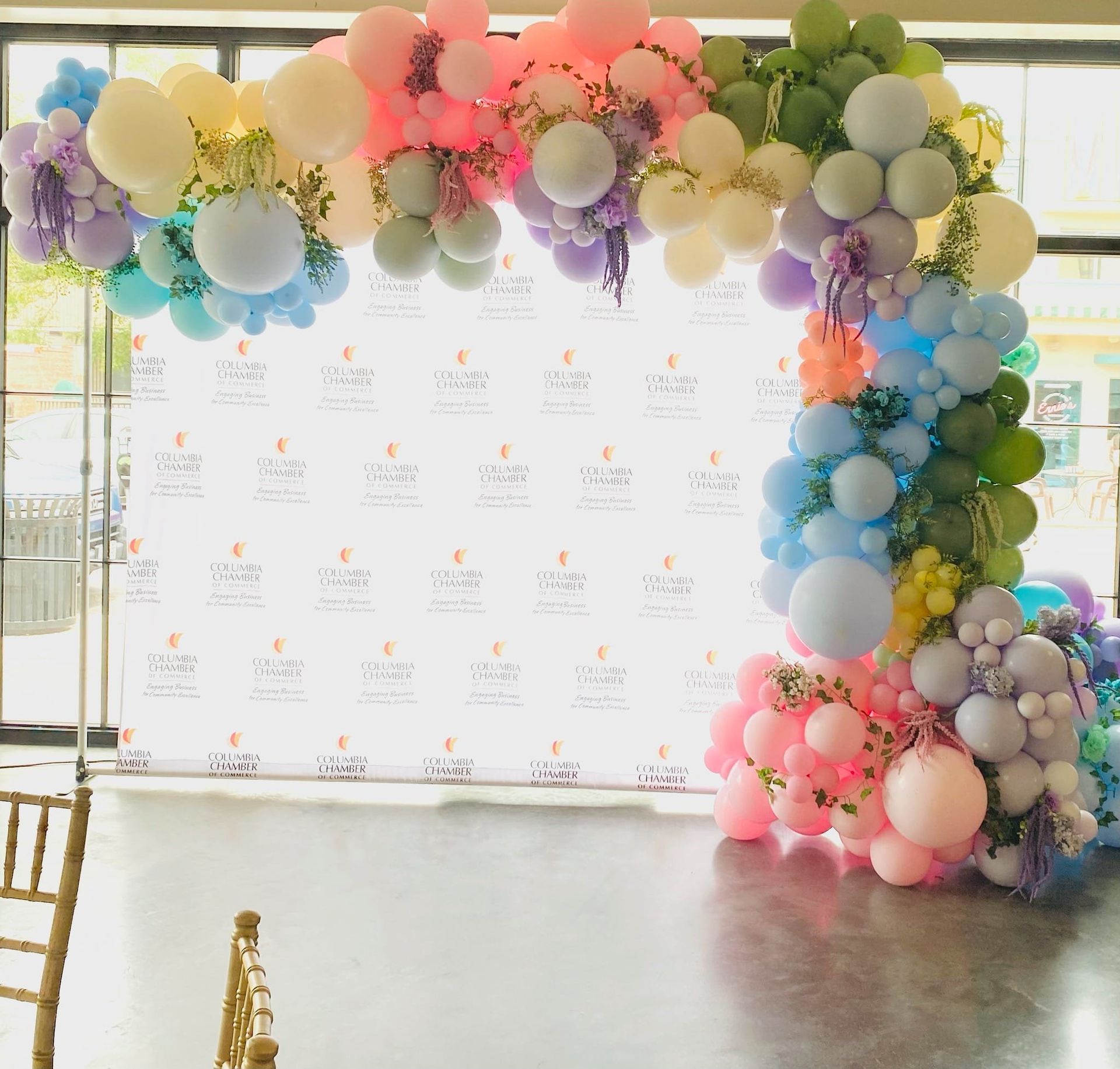 A room filled with lots of colorful balloons and flowers.