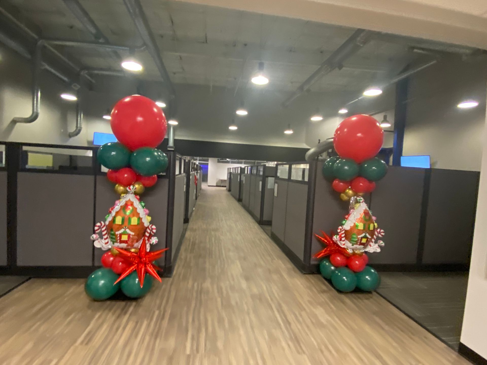 A row of cubicles are decorated with balloons for christmas