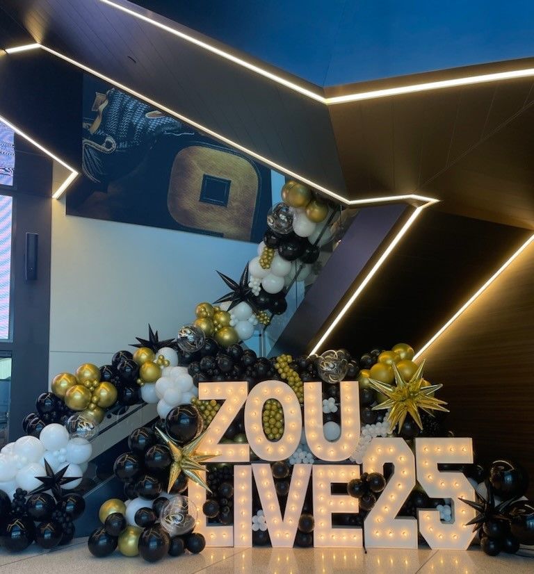 A staircase with balloons and a sign that says zou live25