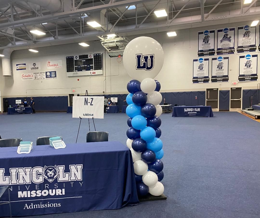 A large room with a table and balloons in it.