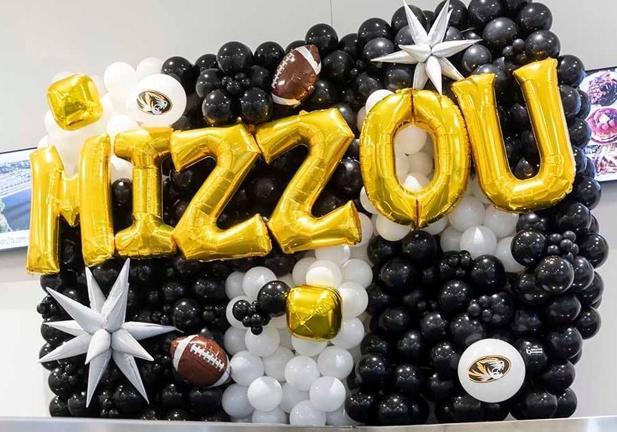 A wall of balloons with the word mizzou on it.