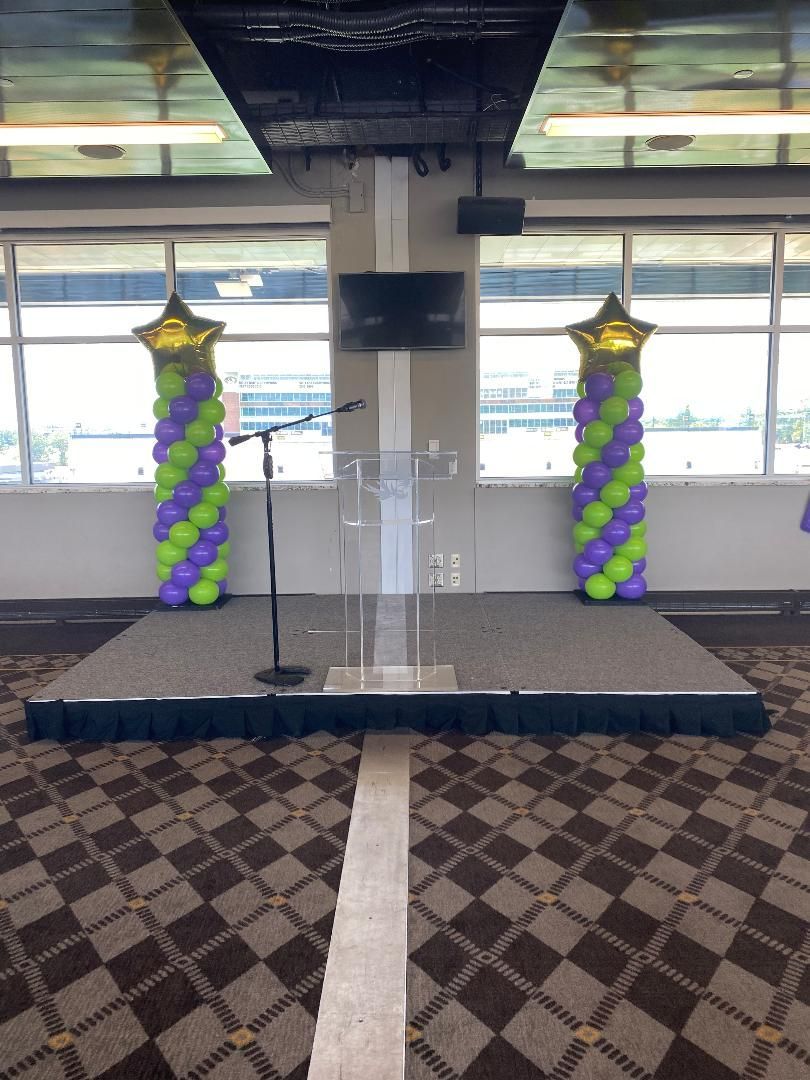 A stage with balloons and a microphone in a room