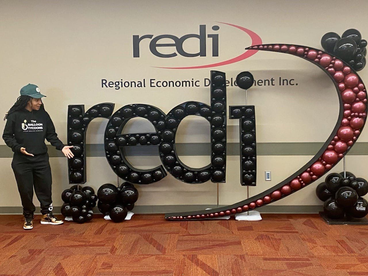 Woman beside a black balloon sculpture of