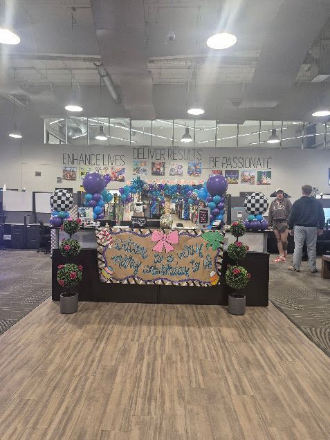 Event table decorated with balloons, checkered flags, and a sign that says