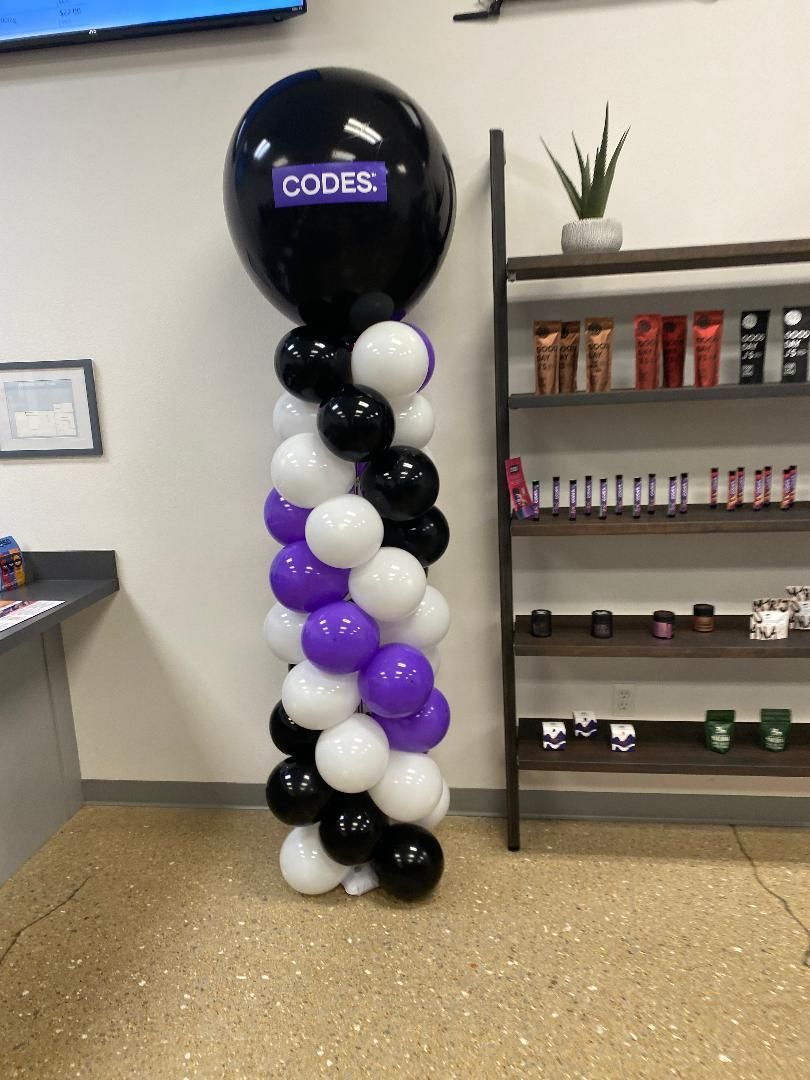 A black and purple balloon with the word codes on it