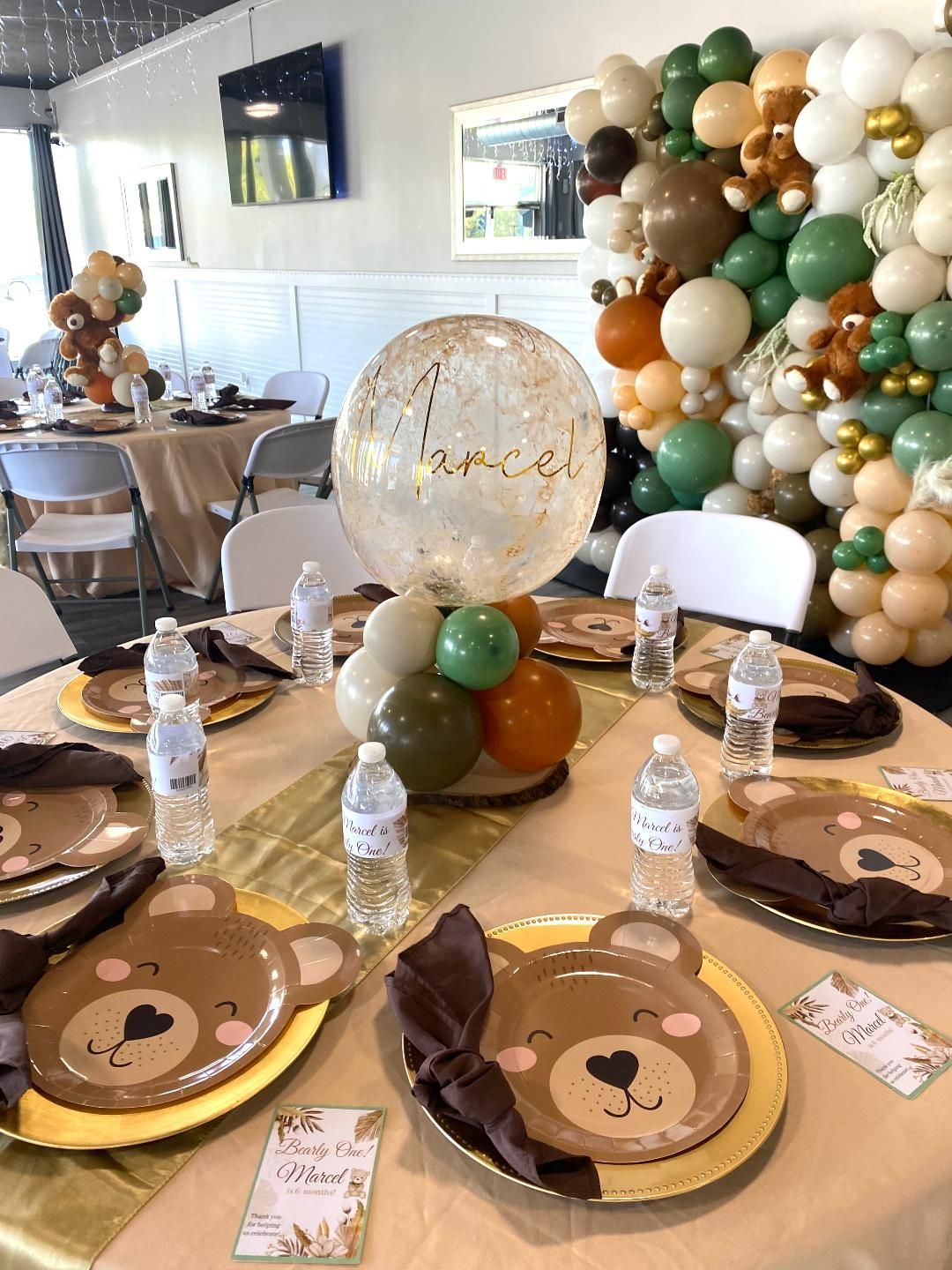 A table set for a baby shower with plates and balloons.