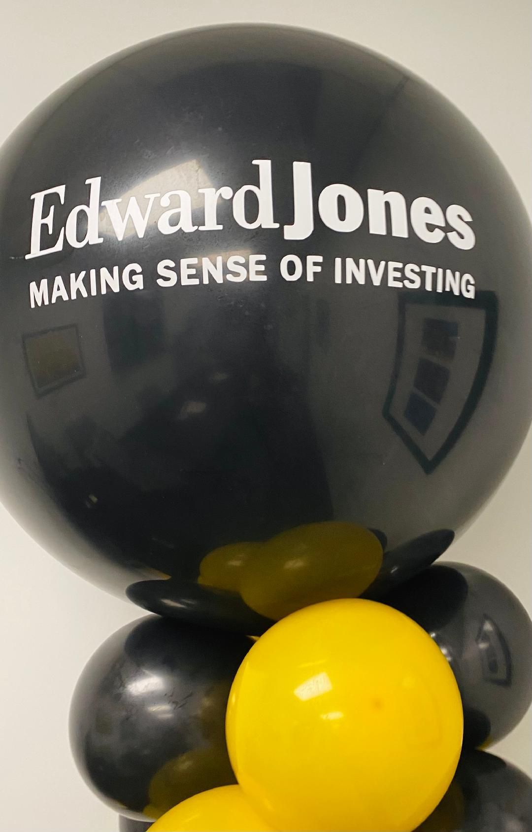 A black edward jones balloon surrounded by yellow balloons