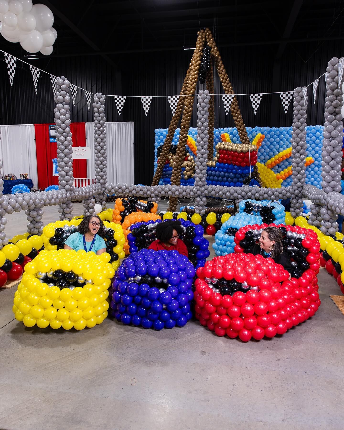 A group of cars made out of balloons in a room
