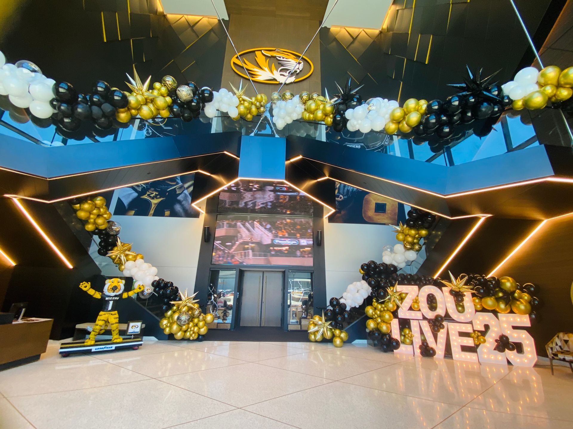 A lobby with balloons and a sign that says zoo live 25