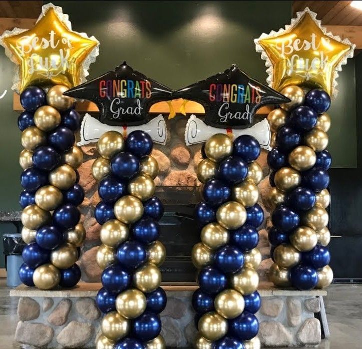 Two columns of blue and gold balloons with congratulations written on them