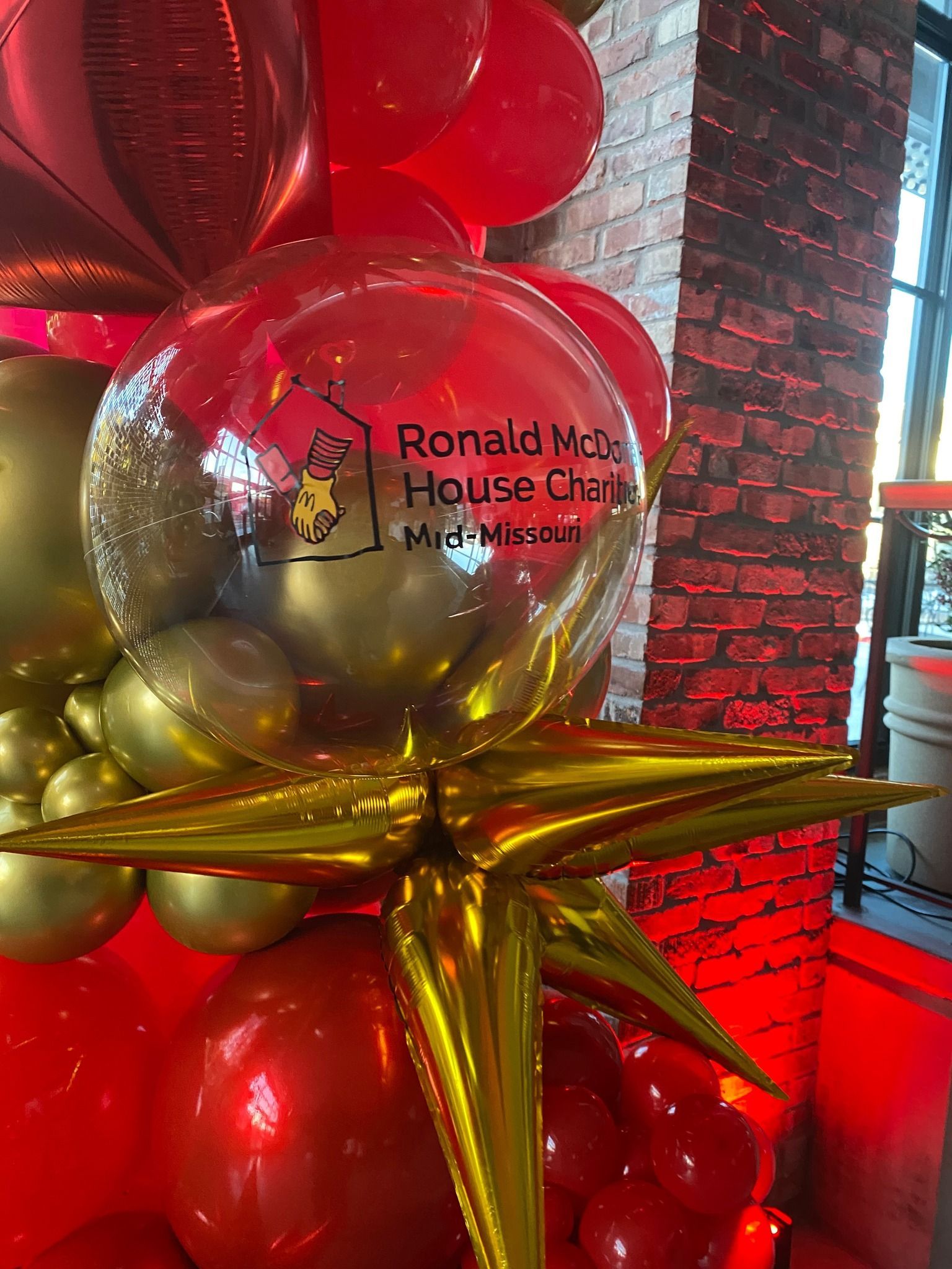 Balloons display for Ronald McDonald House Charities: red, gold, and clear balloons with starburst.