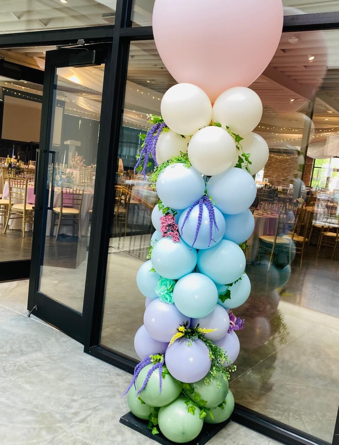 A bunch of balloons are stacked on top of each other in front of a building.