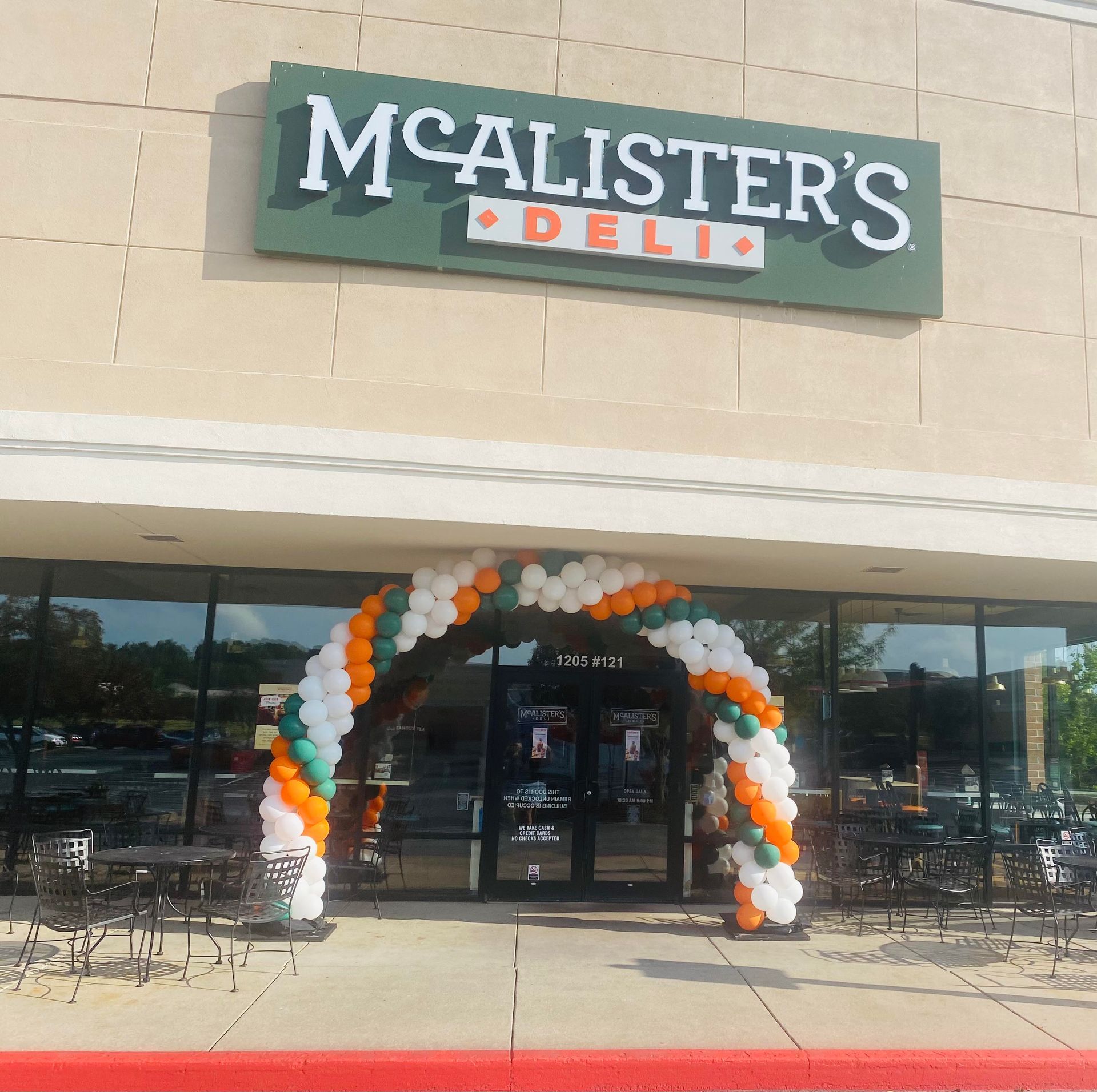 The front of a mcallister 's deli with balloons in front of it