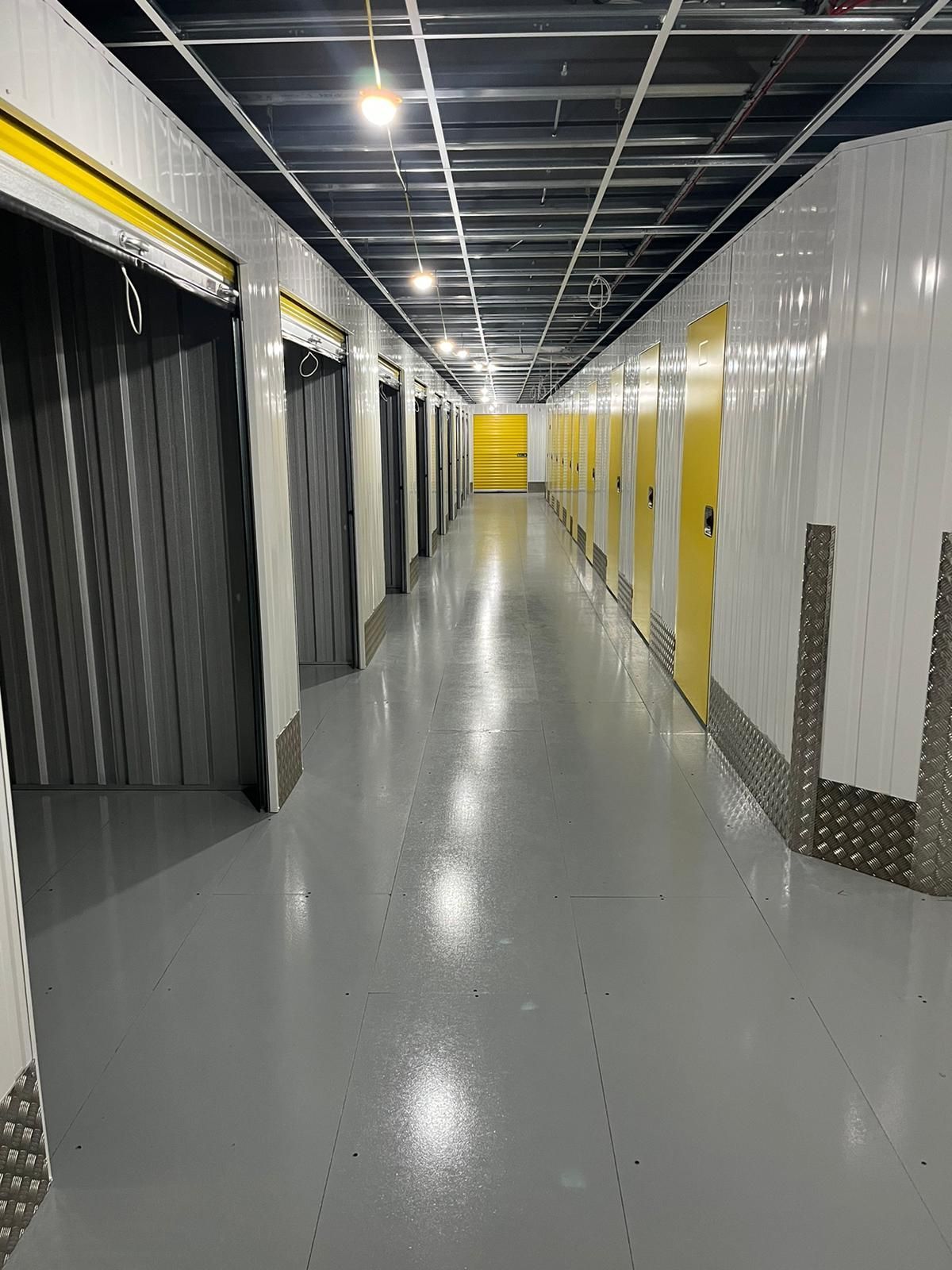 A long hallway filled with lots of lockers and doors.