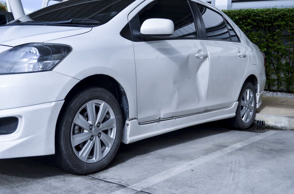A White Car With A Damaged Door Is Parked In A Parking Lot — Summit Smash In Polo Flat, NSW