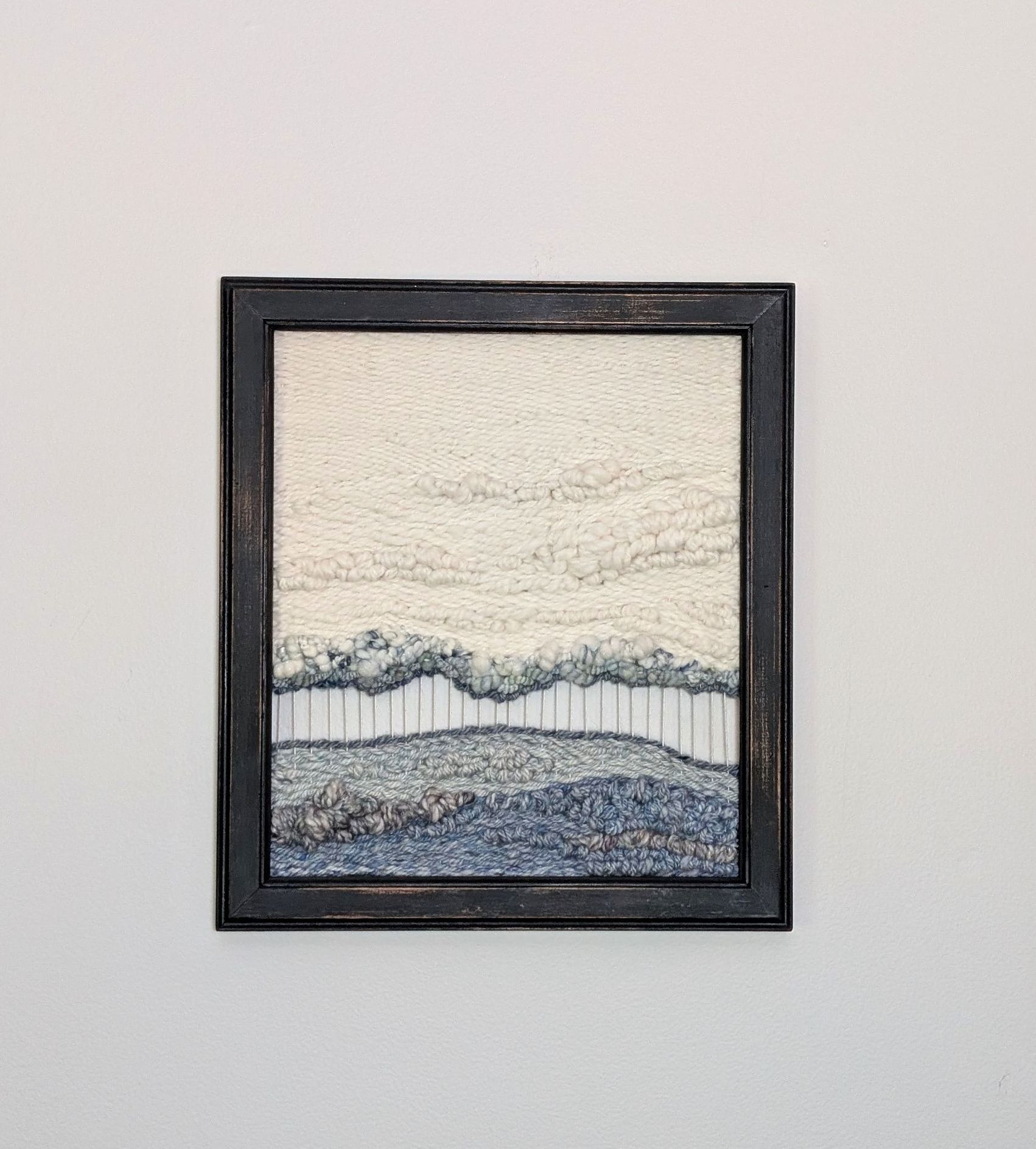blue and cream framed woven tapestry