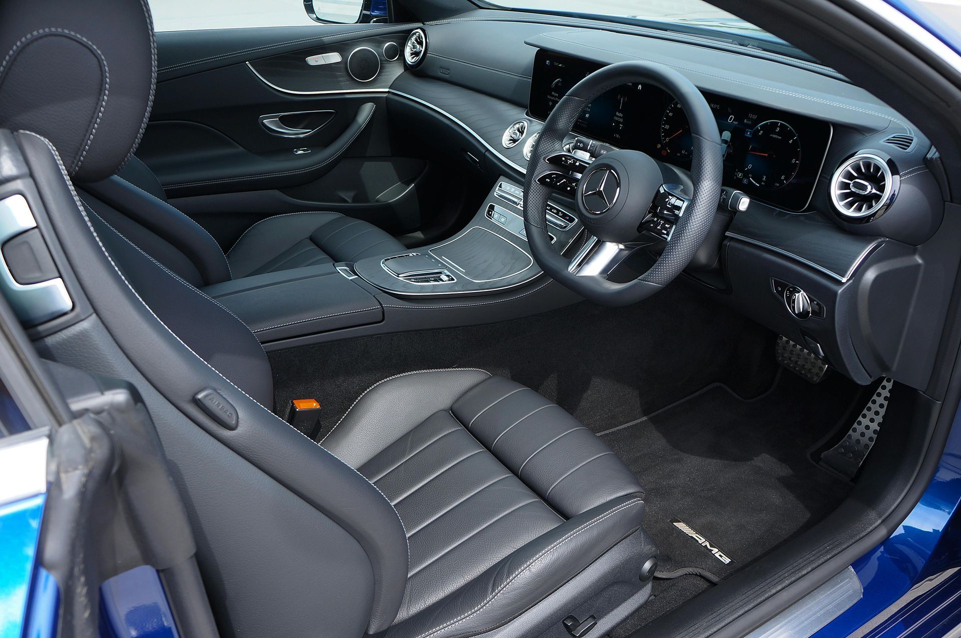 The interior of a blue car with black seats and a steering wheel
