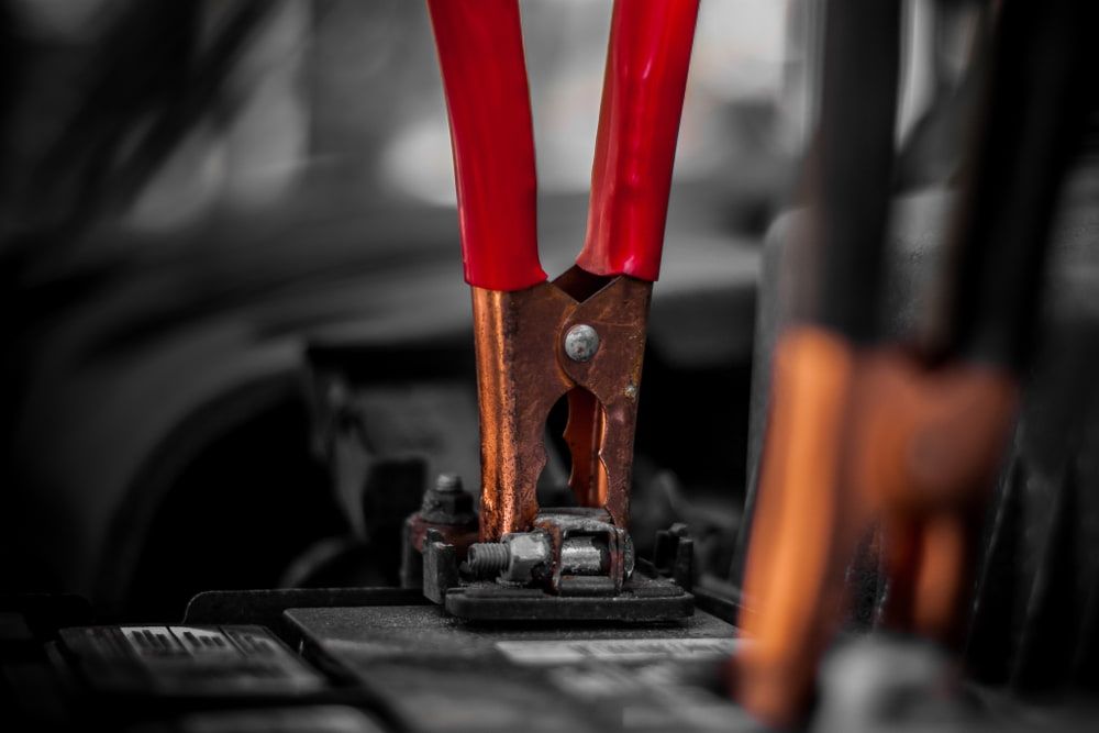 A Close Up Of A Pair Of Pliers Attached To A Car Battery — 4off Automotive & Electrical In Bowral, NSW