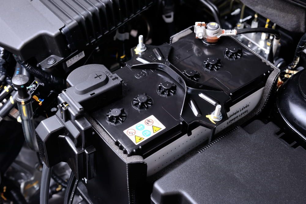 A Car Battery Is Sitting Under The Hood Of A Car — 4off Automotive & Electrical In Bowral, NSW
