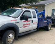 White tow truck with the phone number 313-478-5333 and the text “Cash for junk cars on the spot.” White tow truck with the phone number 313-478-5333 and the text “Cash for junk cars on the spot.”