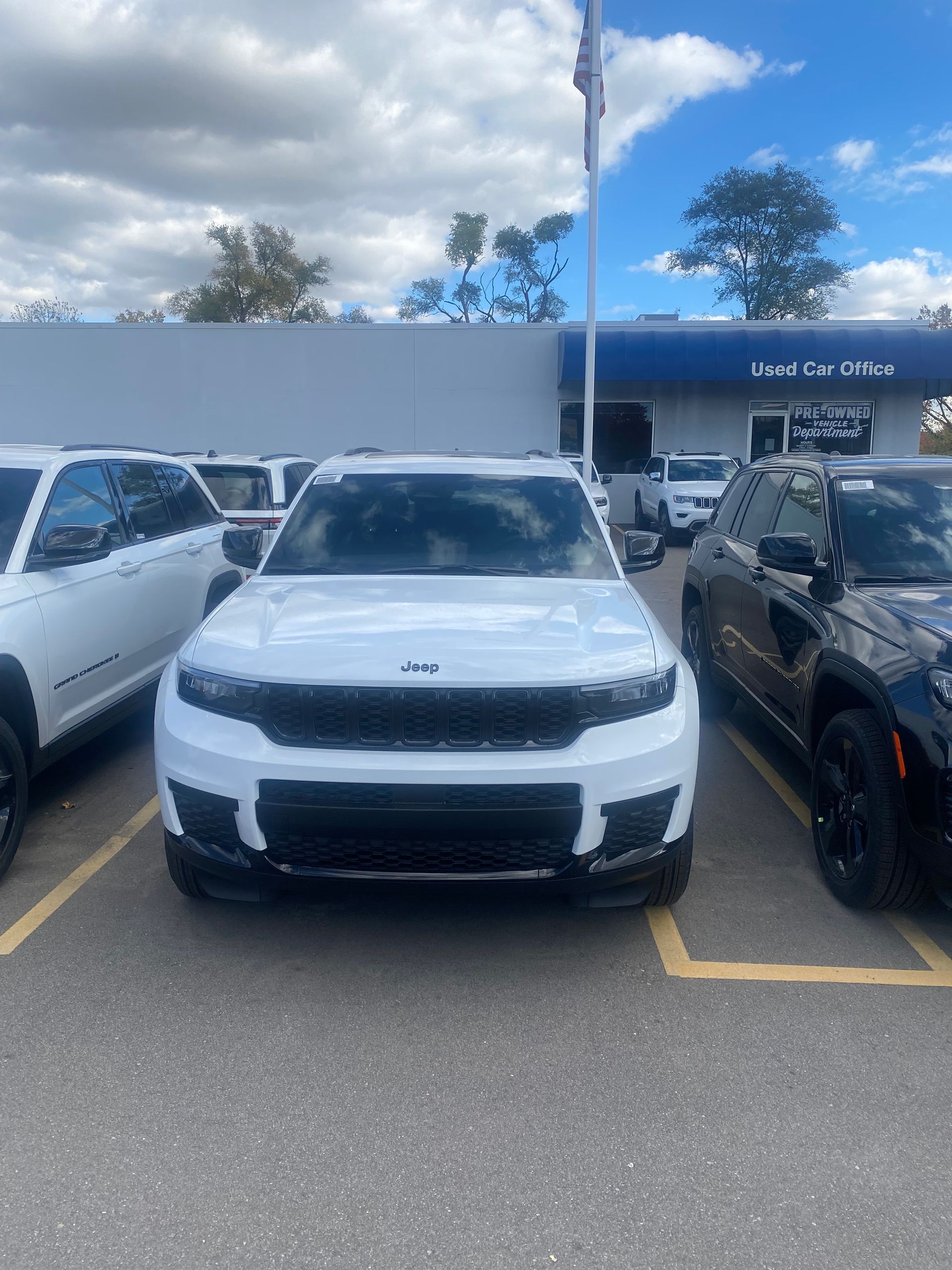 Cars parked closely together in an outdoor parking lot; various colors and models.