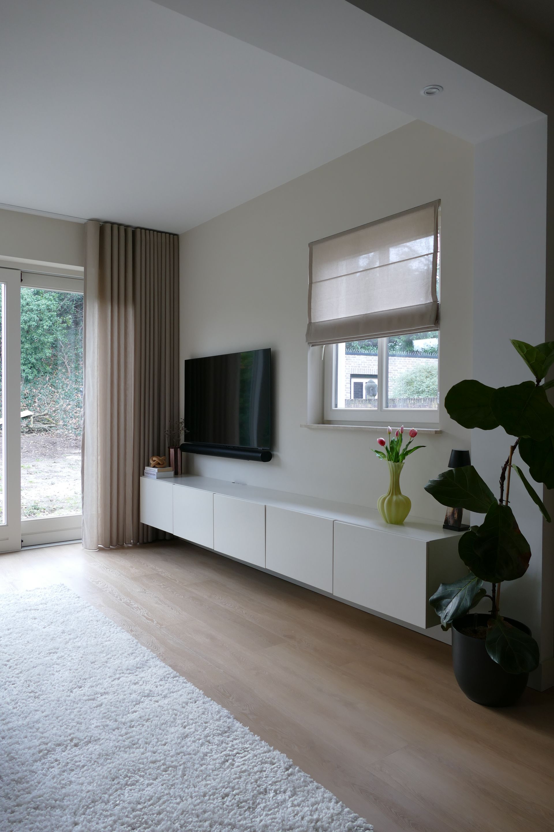 Tv meubel zwevend met groene vaas