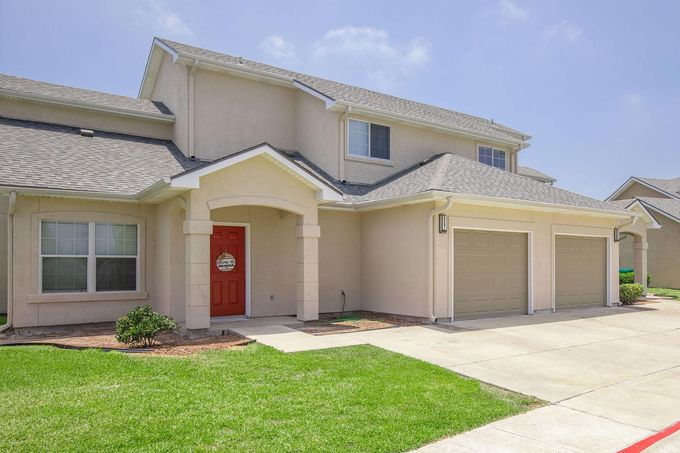 A white house with a red door and two garages  at Windy Shores.