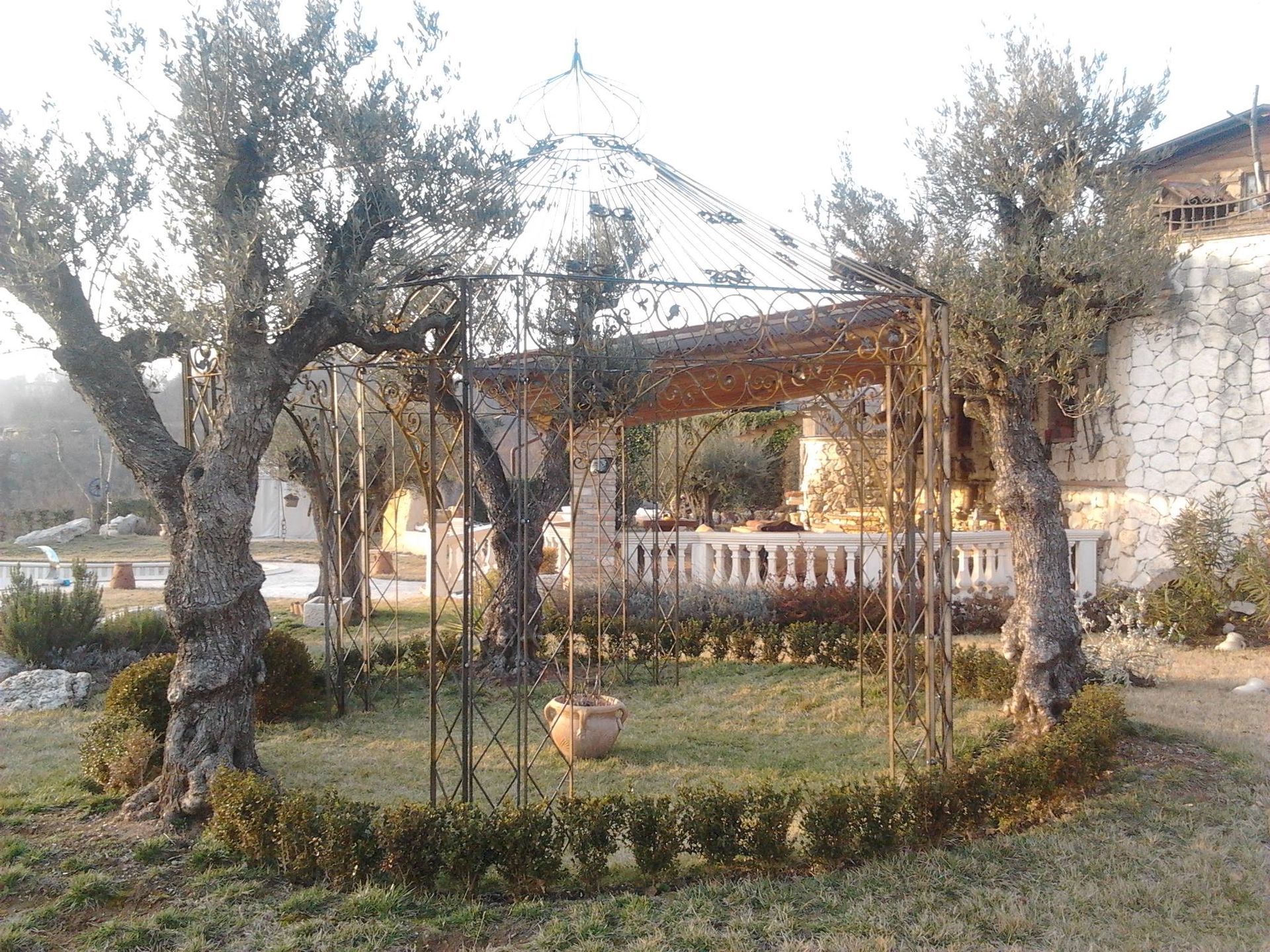 un gazebo in un giardino circondato da alberi