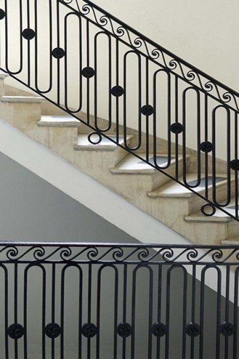 un primo piano di una scala con una ringhiera in ferro battuto