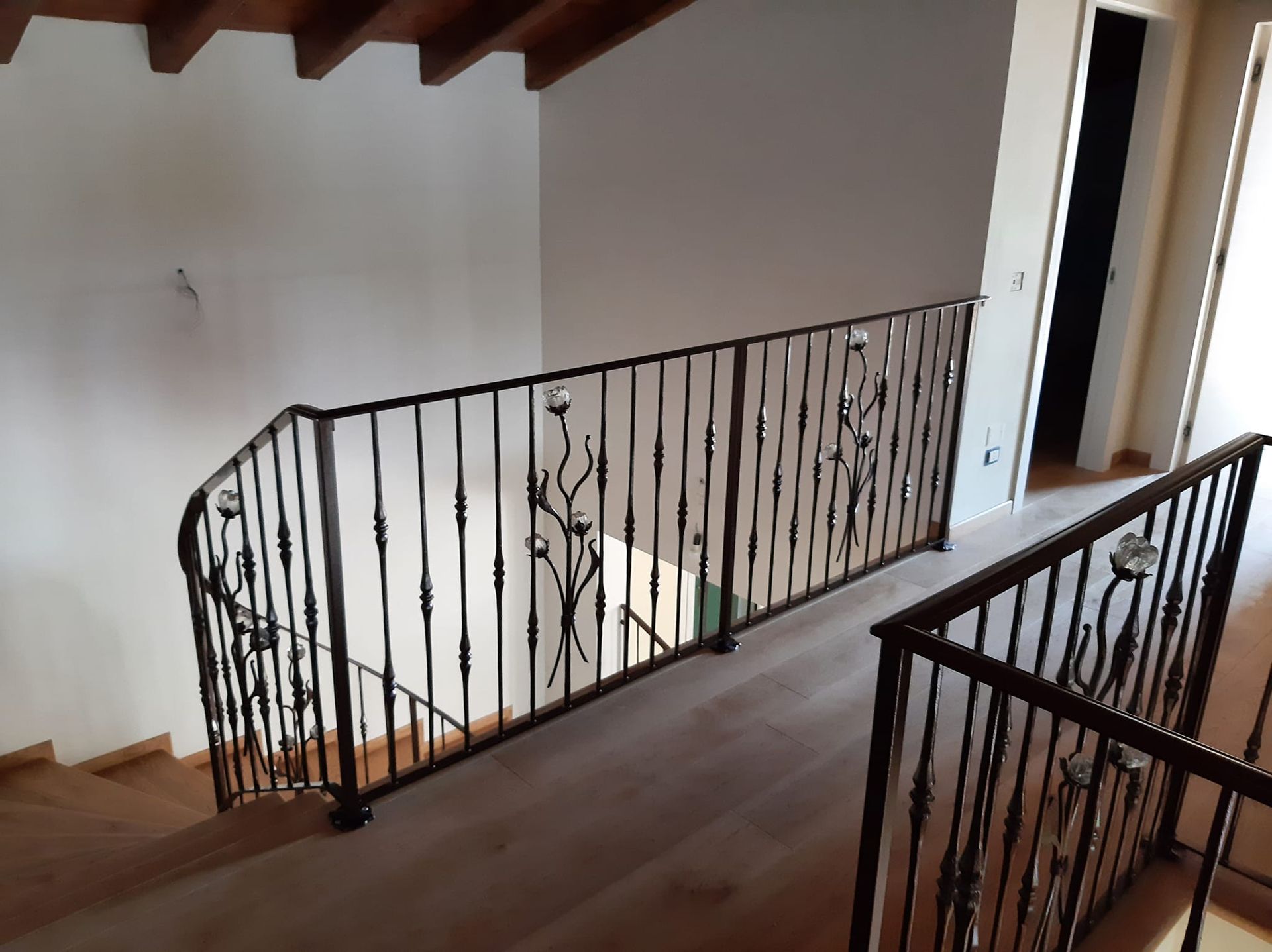 una scala con una ringhiera in ferro battuto in una casa