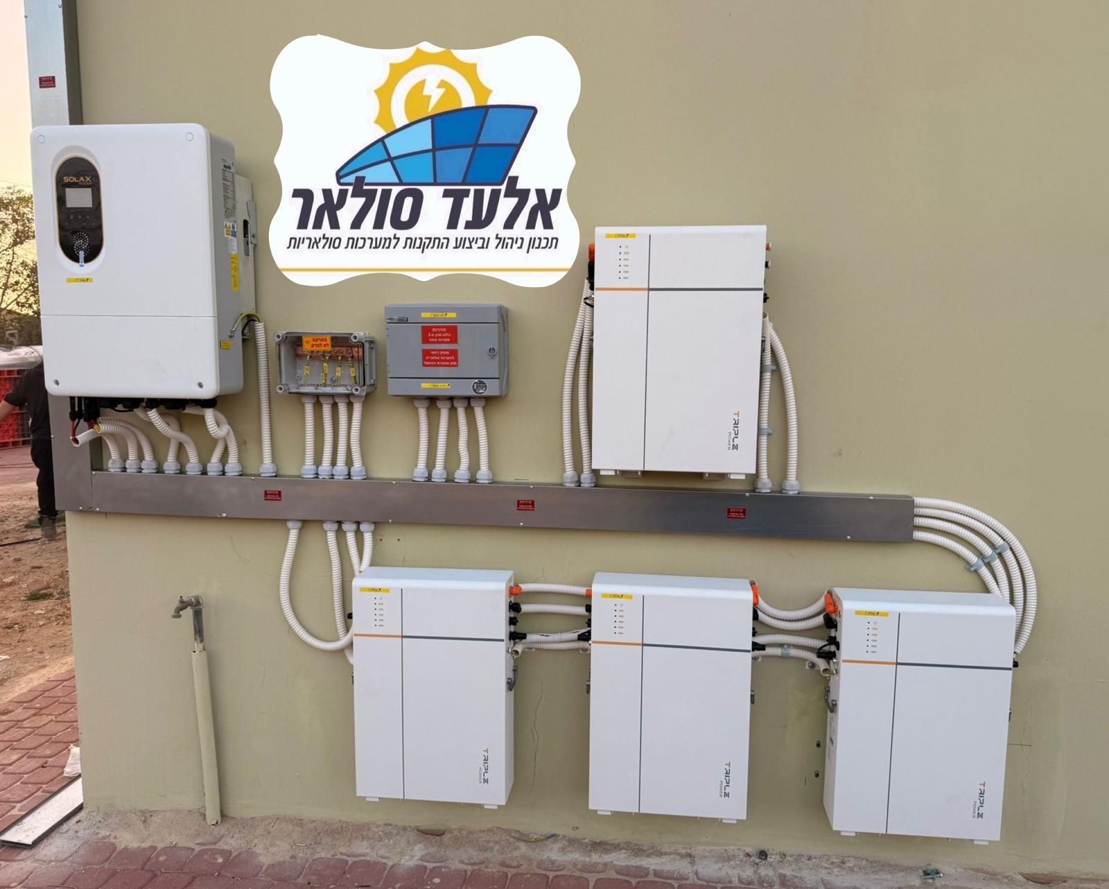 כבלי חשמל אדומים וירוקים מסתעפים על גג מתכת גלי, ליד מבנה תומך מתכת.