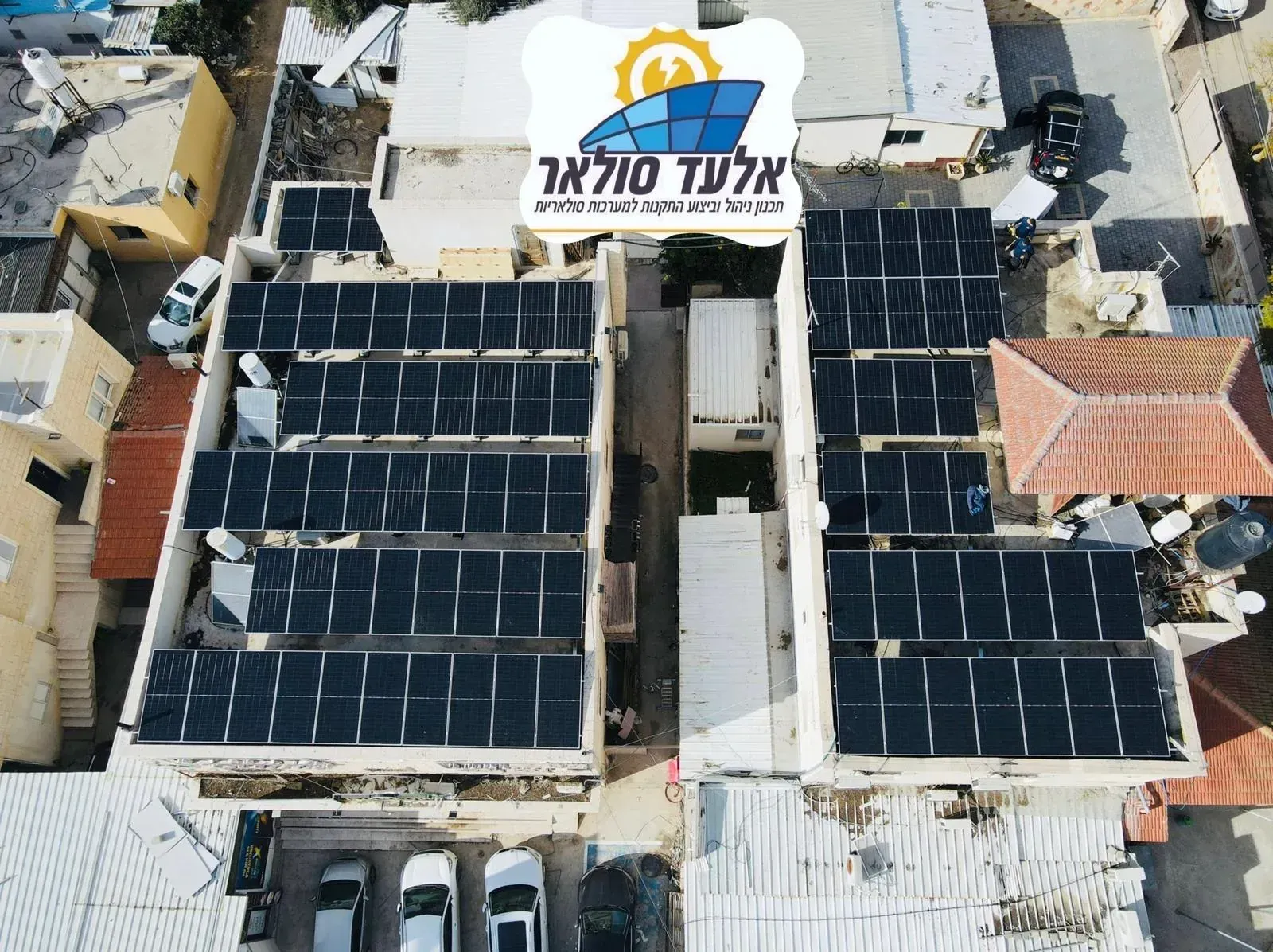 פאנלים סולאריים על גג בניין עם שילוט בעברית, מבט מלמעלה