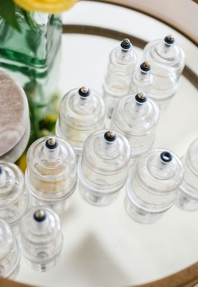 a bunch of clear cups on a tray with a flower in the background
