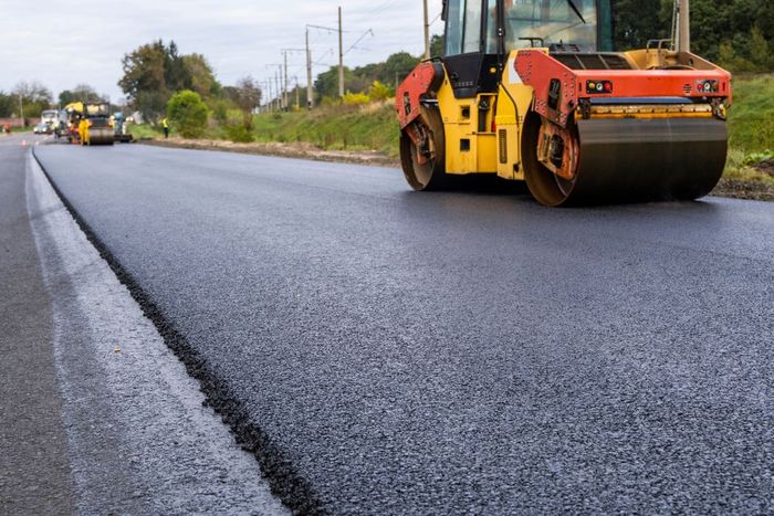 A roller is rolling asphalt on a road.
