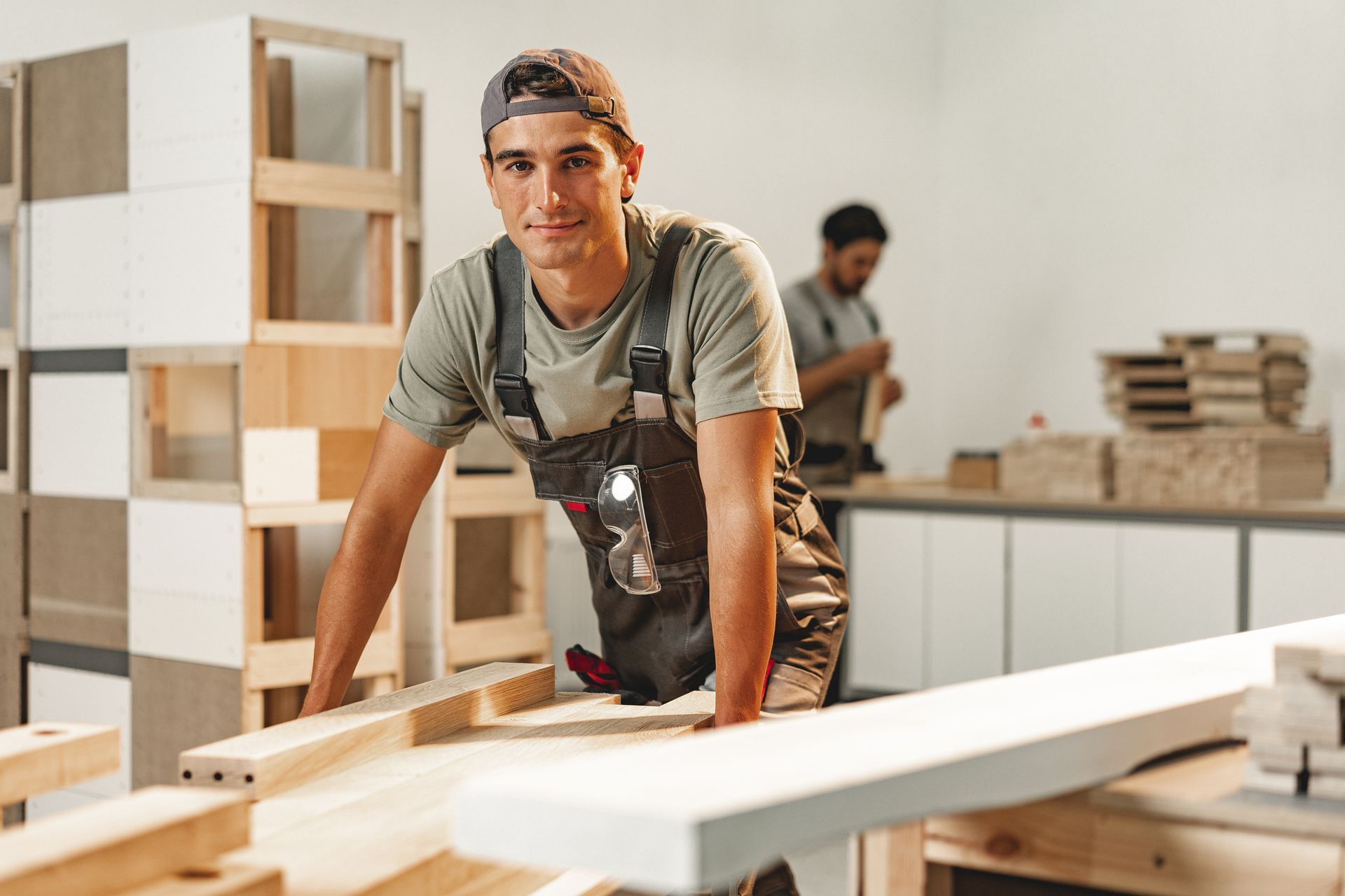 Portrait of a young male carpenter standing in a wood workshop