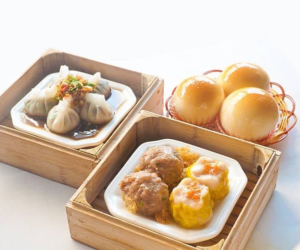 Dim sum platter: dumplings, buns, and siu mai in bamboo steamers.
