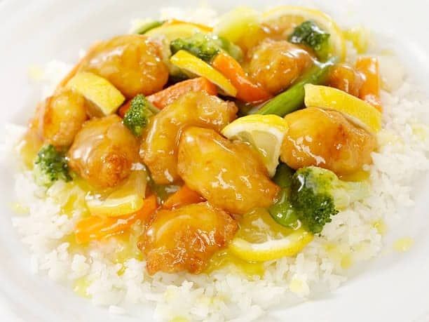 Lemon chicken with vegetables over white rice.