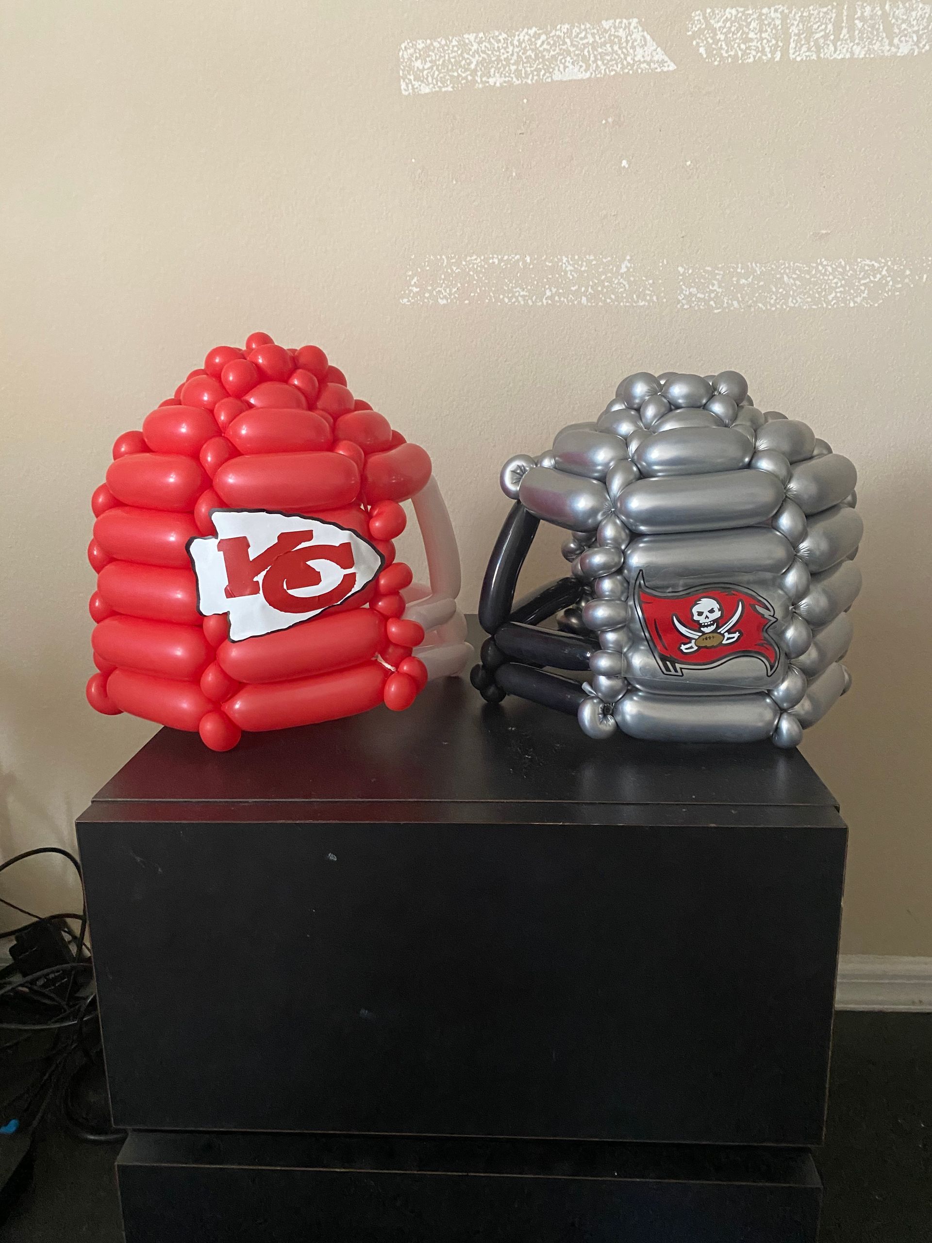 Two football helmets made out of balloons are sitting on a table.