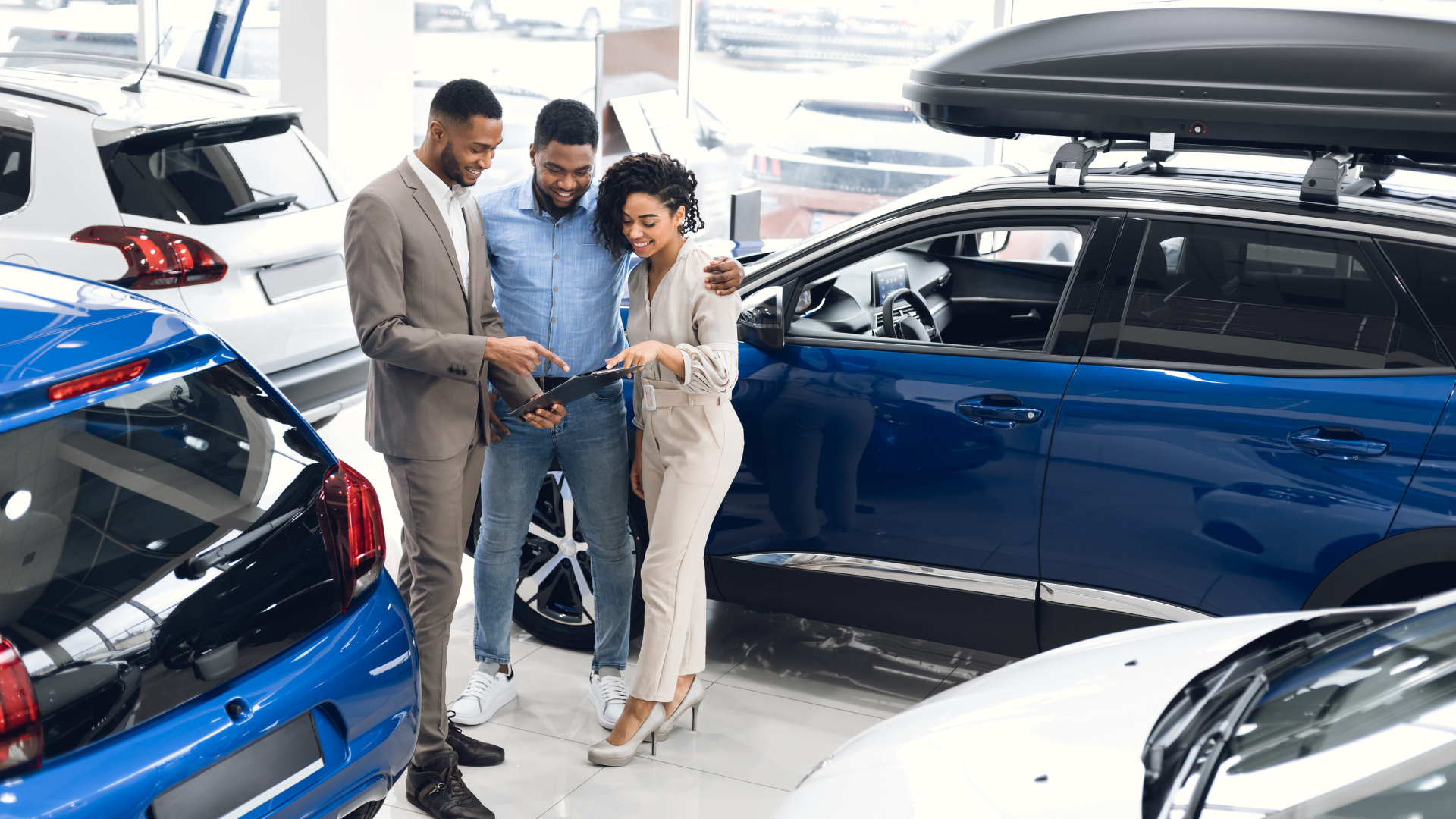A group of people are looking at a car in a showroom.