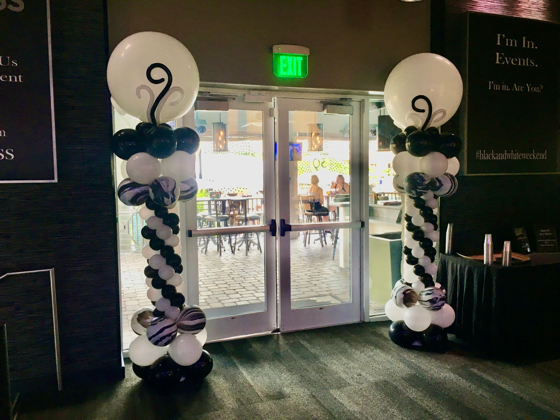 A couple of balloon columns are sitting in front of a door.