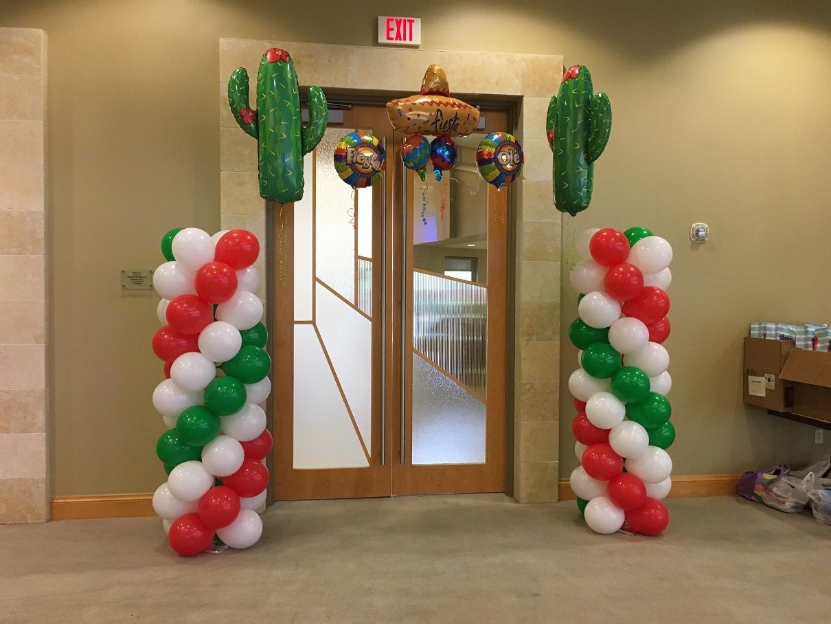 A room decorated with balloons and cactus shaped balloons